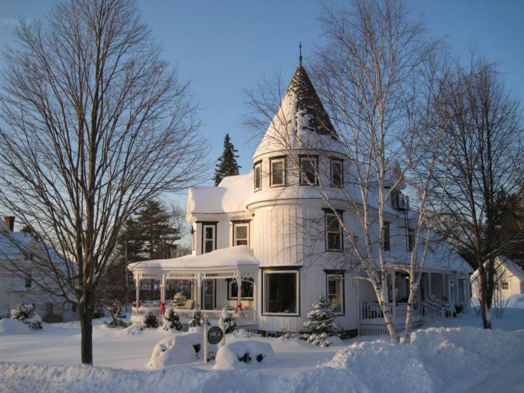 阿什兰格林豪斯酒店的雪中带塔楼的大型白色房屋
