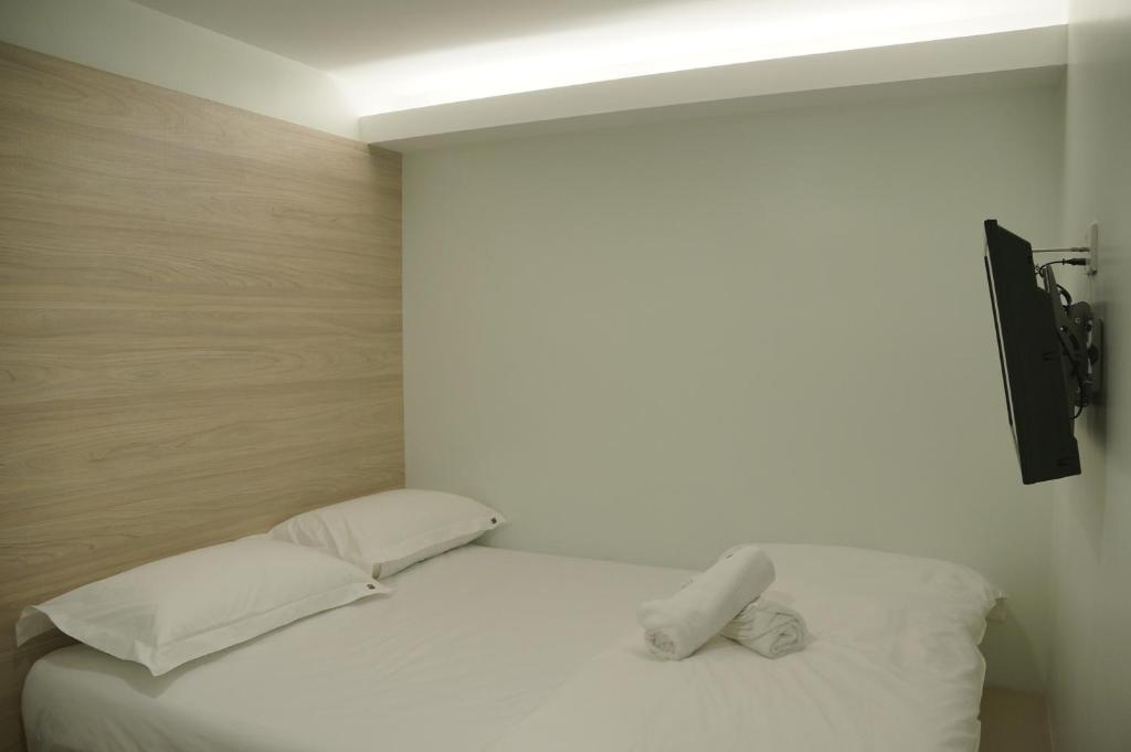 梳邦再也梳邦再也57号 USJ 21酒店的一间卧室配有带白色床单和枕头的床。