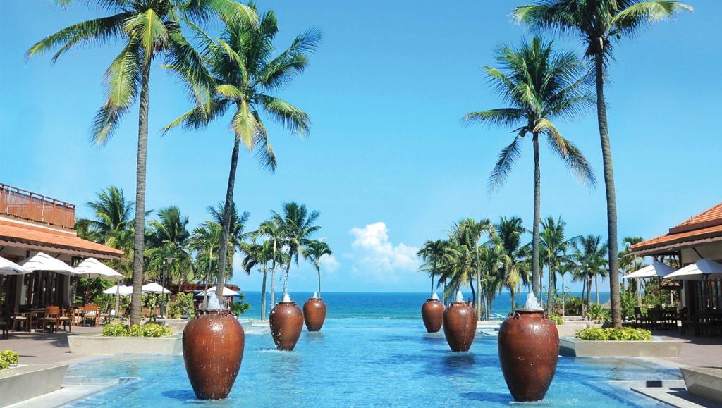 岘港岘港富丽华大酒店 的水中大花瓶的度假胜地的游泳池