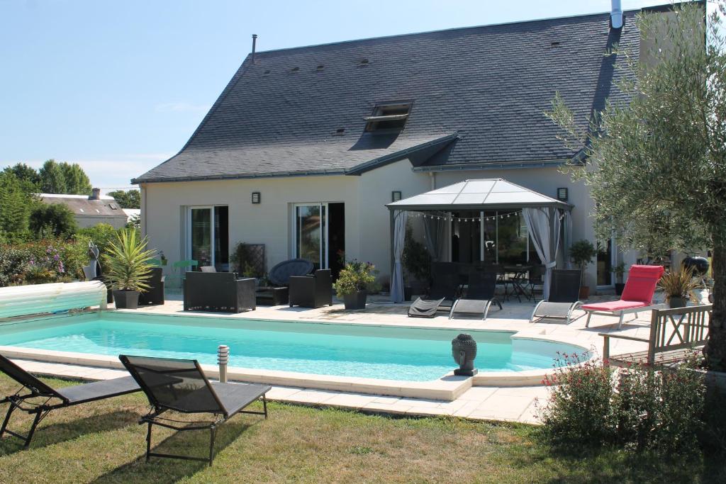 Saint-Gervais en-Belin农场住宿加早餐旅馆的房屋前的游泳池
