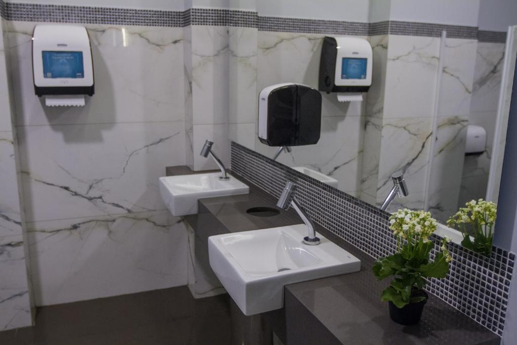 帕图斯迪米纳斯Fratele Business Hotel的配有两个盥洗盆和镜子的公共浴室
