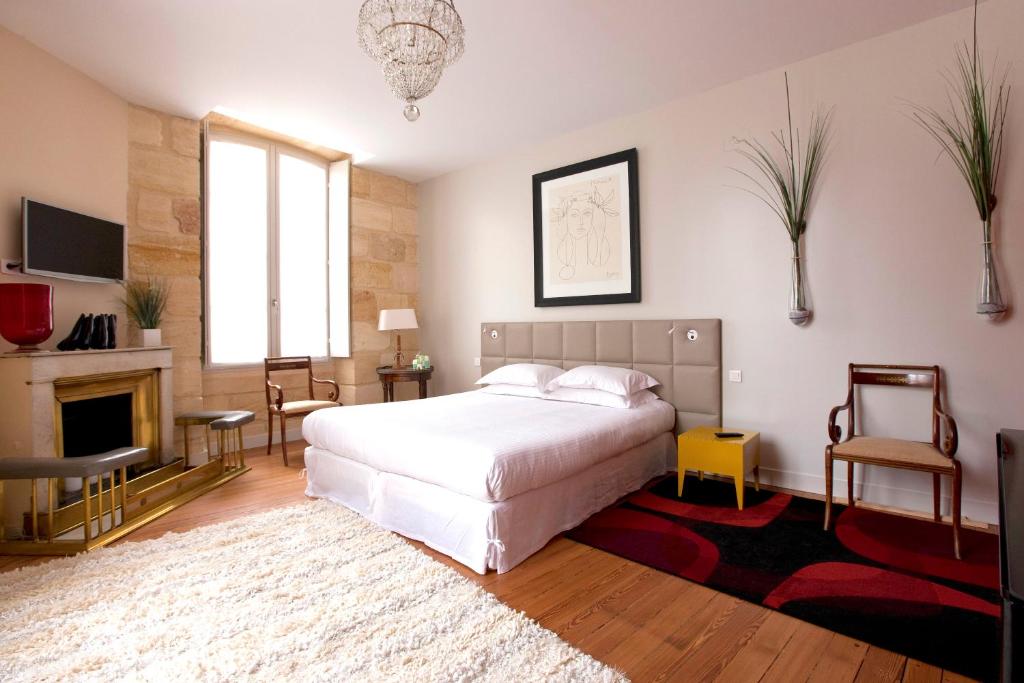 波尔多安尼克司杜邦酒店的卧室配有白色的床和壁炉