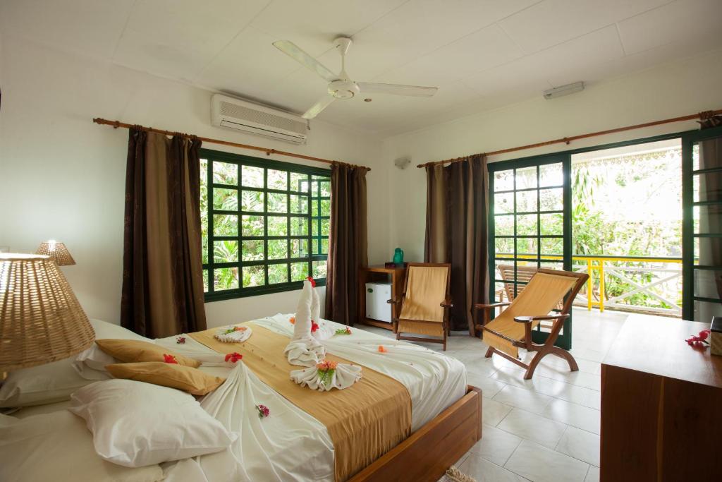 拉迪格岛米歇尔旅馆的一间带一张大床的卧室,位于带窗户的房间内