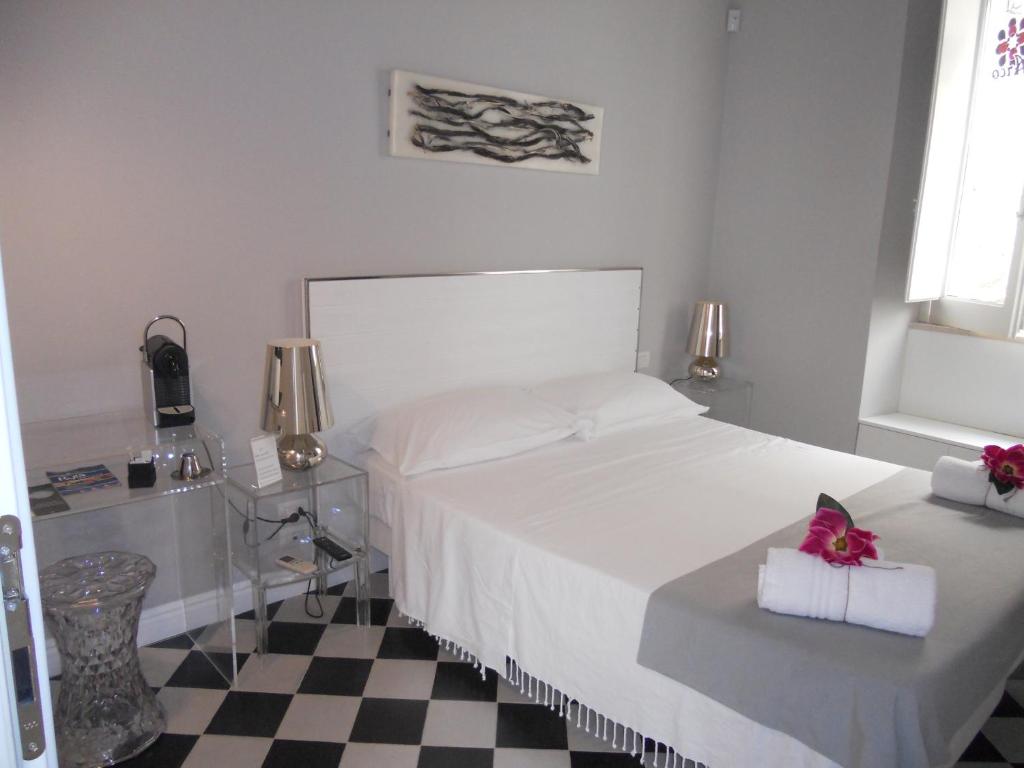 特拉尼Arco' B&B的卧室配有白色的床和 ⁇ 格地板