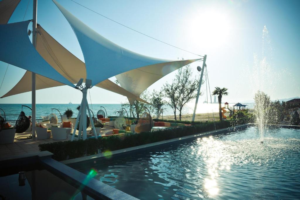 巴库新月海滩酒店的一个带喷泉和遮阳伞的游泳池