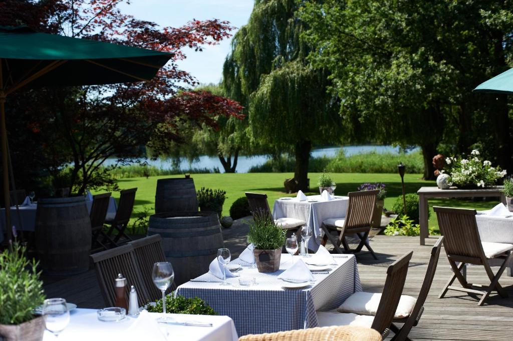 加尔布森兰道思安木思酒店的一间湖景餐厅,配有桌椅