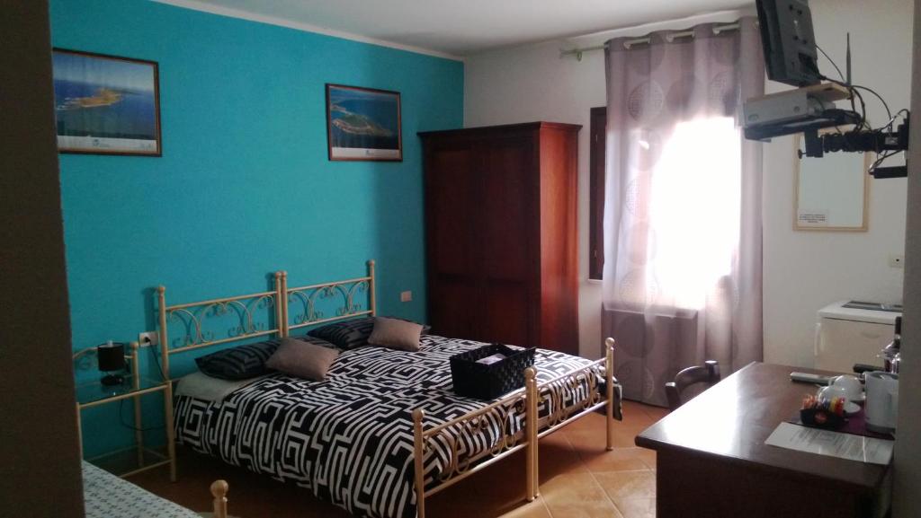 卡布拉斯西尼斯雕像旅馆的一间卧室设有一张床和蓝色的墙壁