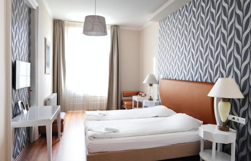 布达佩斯八角形房舍酒店的配有一张床和一张书桌的酒店客房