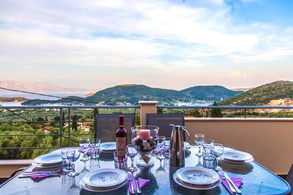 奈德里Villa Maria & George的阳台上的桌子上摆放着玻璃杯和一瓶葡萄酒