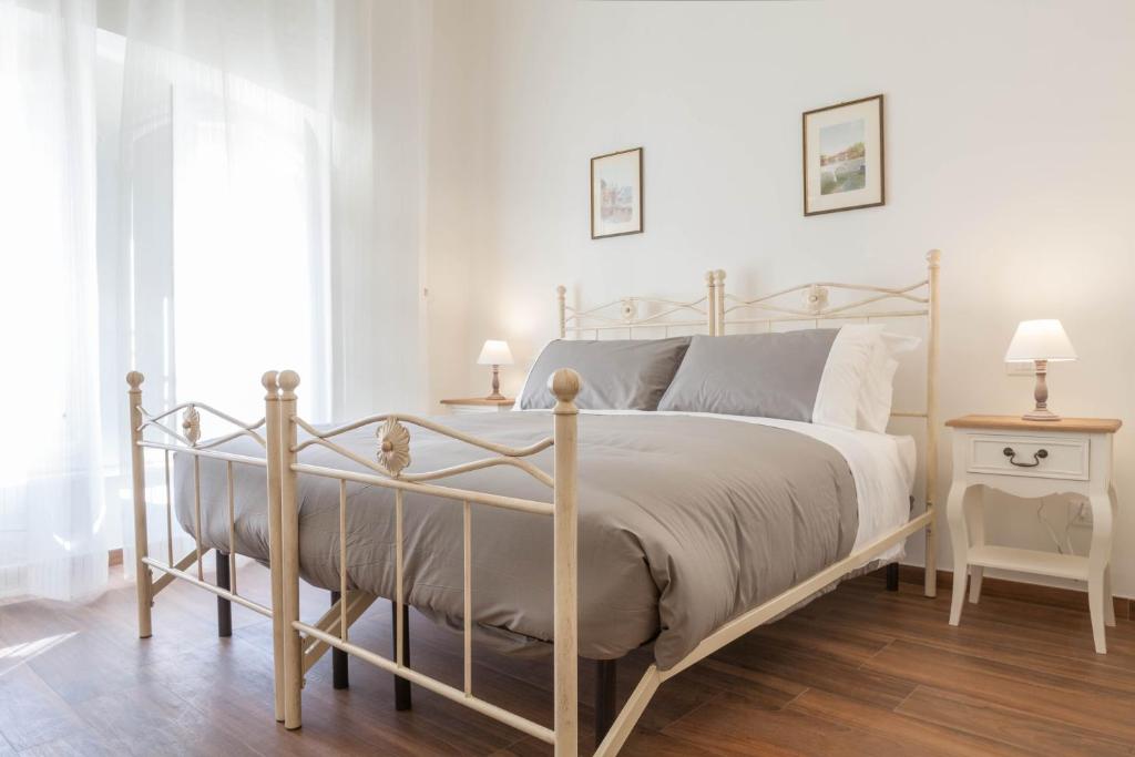罗马唐娜玛格丽特​​罗马套房酒店的白色卧室,配有带金属框架的床