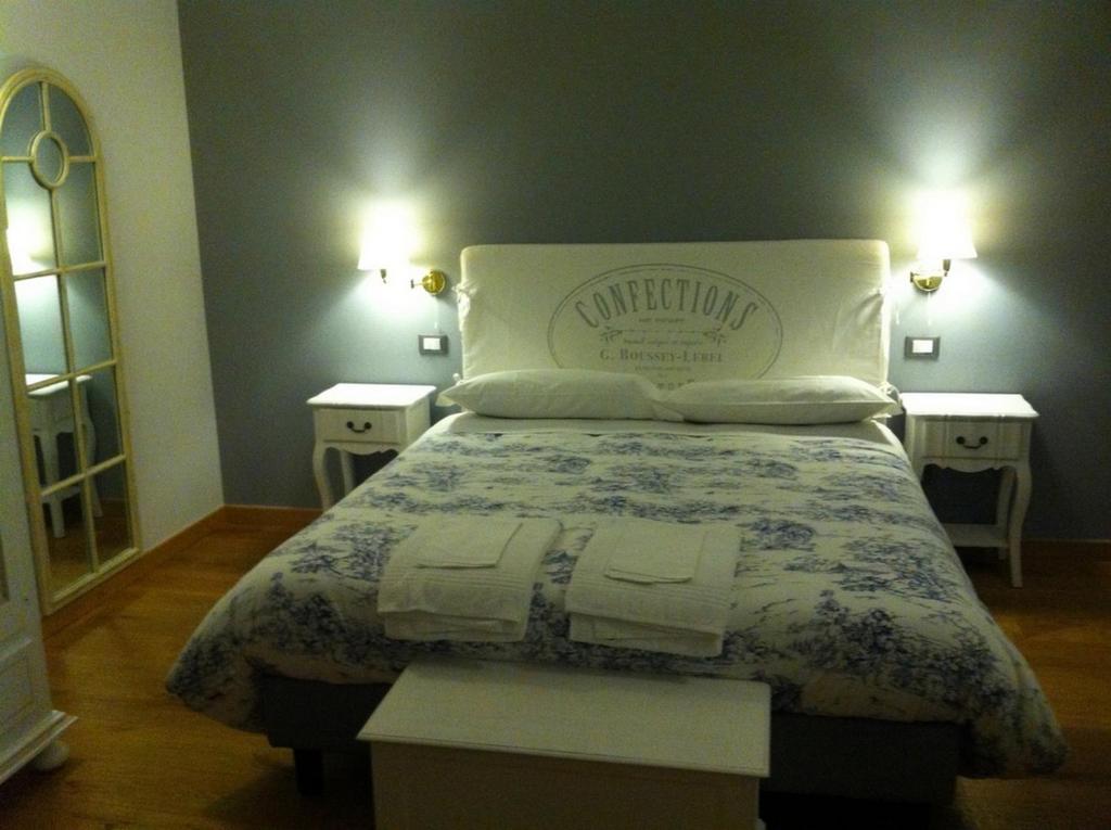 PonzoneRelais Ristorante Sanfront的一张床位,房间设有两个床头柜和两张桌子