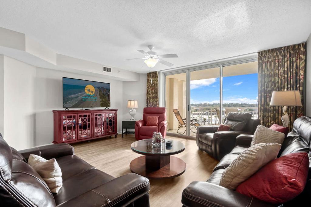 默特尔比奇Yacht Club Villas 1-505 - Marina View的客厅配有真皮沙发和电视