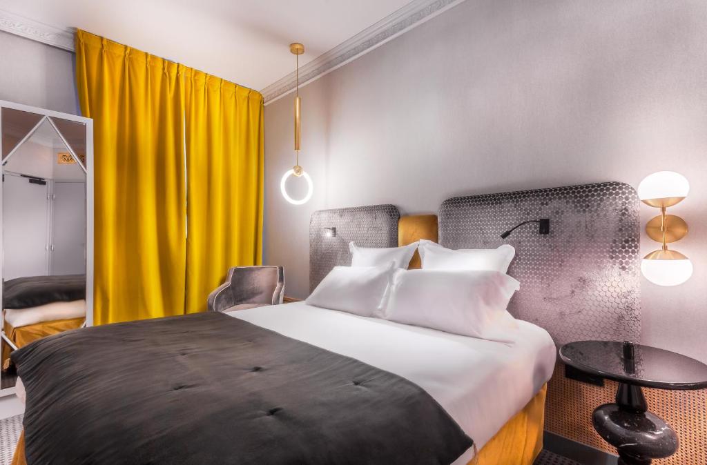 巴黎Handsome Hotel的酒店客房,设有床和黄色窗帘