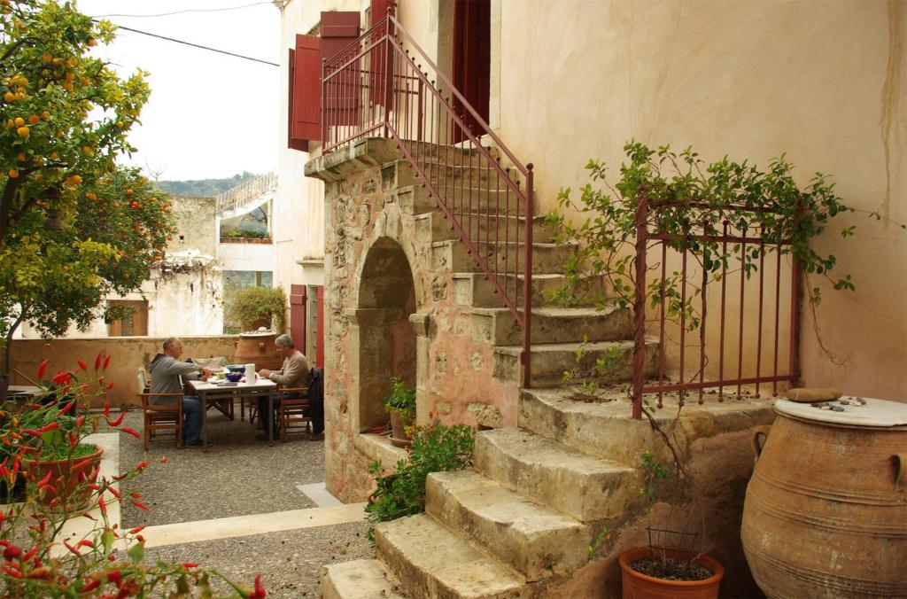 VóroiSior Nikoletos的户外庭院设有楼梯,客人坐在桌子旁