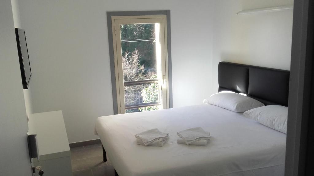 芒通乐瑞莱德蒙蒂宾馆的一张带两个枕头的白色床和窗户