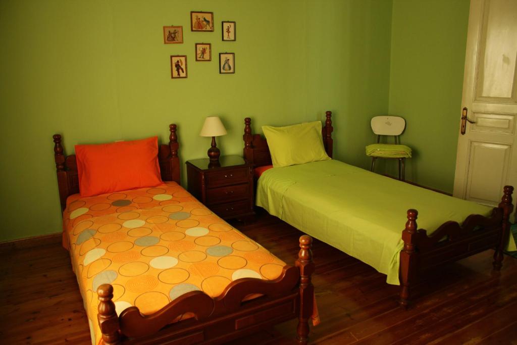干尼亚Kyra Vintage House的卧室设有两张床,拥有绿色的墙壁和木地板