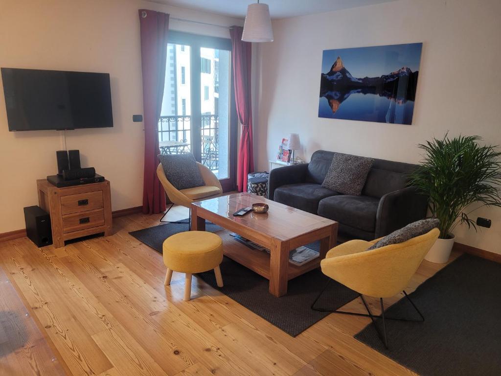 夏蒙尼-勃朗峰Cham&#39;Heart, 4-star apartments in Chamonix centre with free private parking的带沙发和桌子的客厅