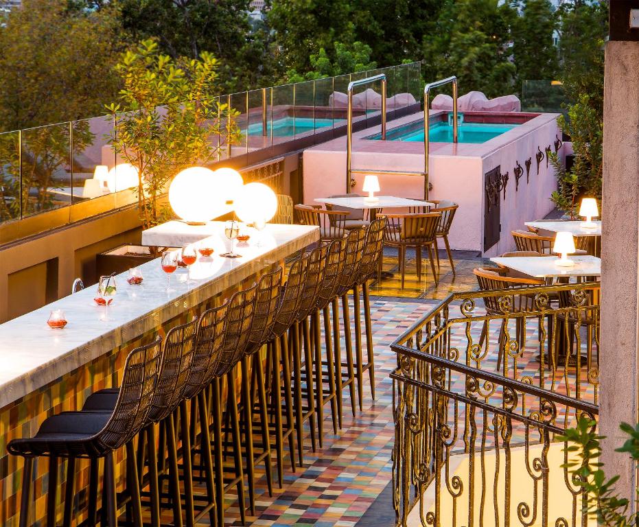 圣地亚哥卢西亚诺K酒店的一间带桌椅的餐厅和一个游泳池
