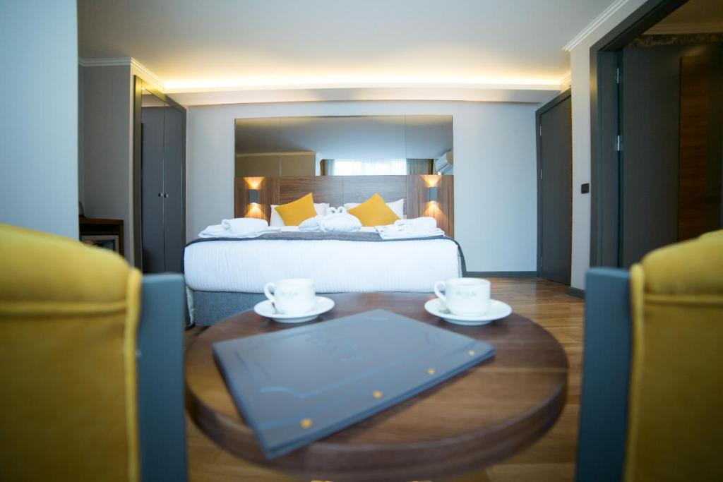 安卡拉安卡拉套房公寓酒店的酒店客房,配有床和桌子及两个杯子