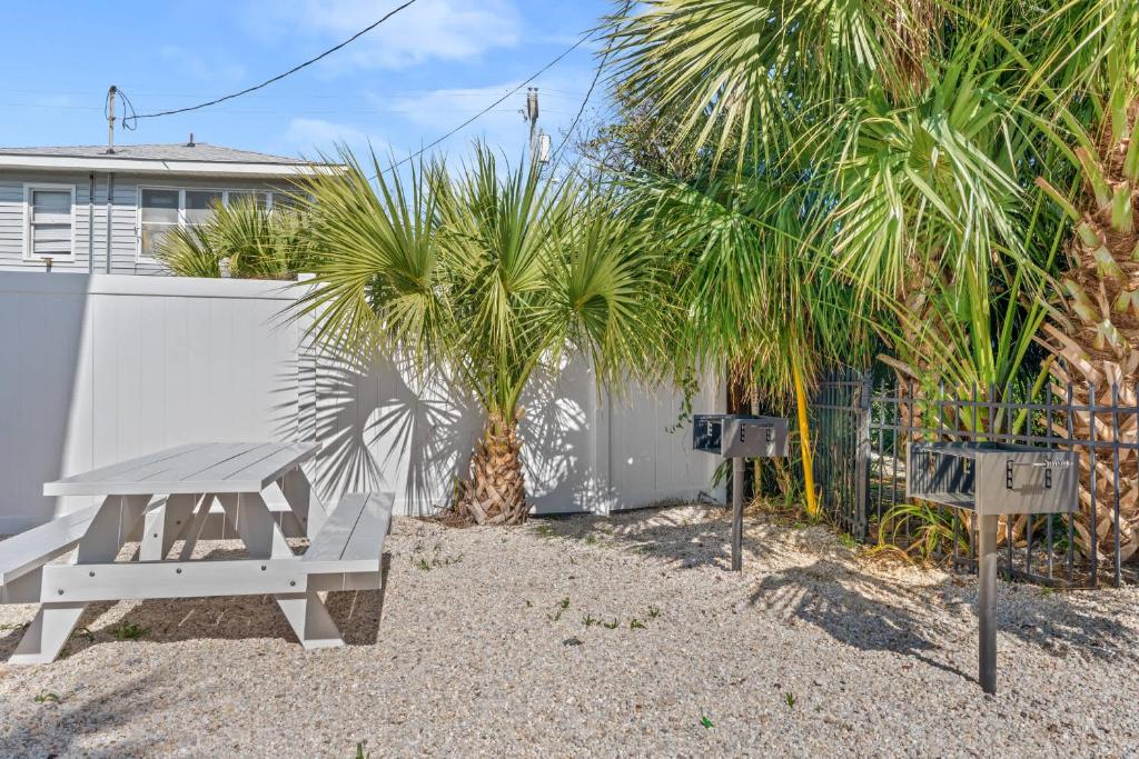 默特尔比奇Cozy Beachside Bungalow Studio Ideal for Couples的棕榈树围栏前的野餐桌