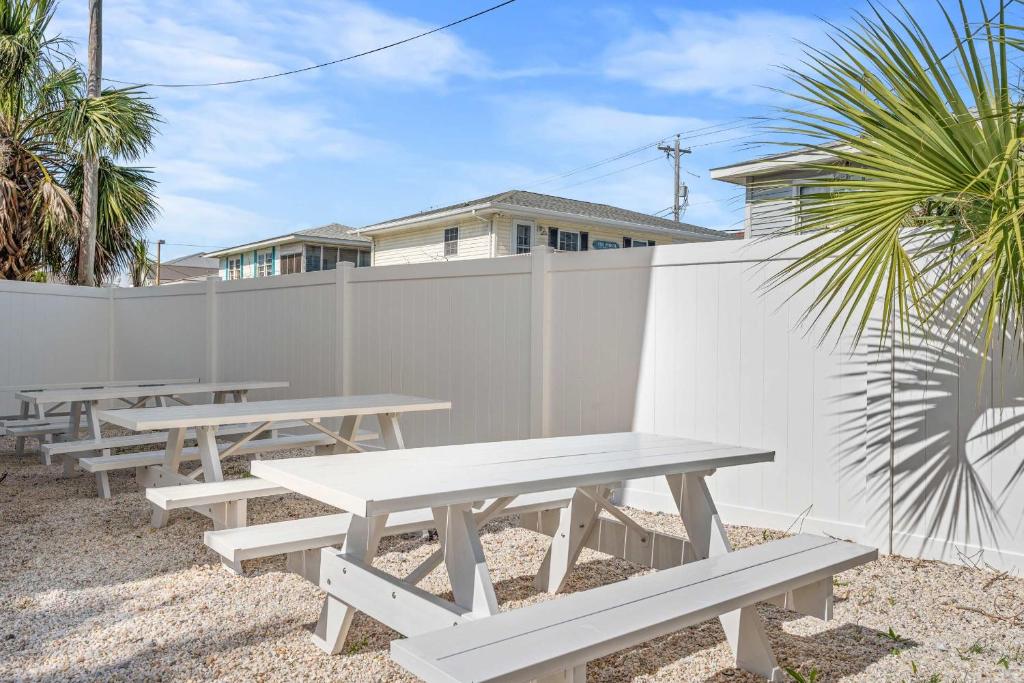 默特尔比奇Cozy Beachside Bungalow Studio Ideal for Couples的围栏前的几排野餐桌