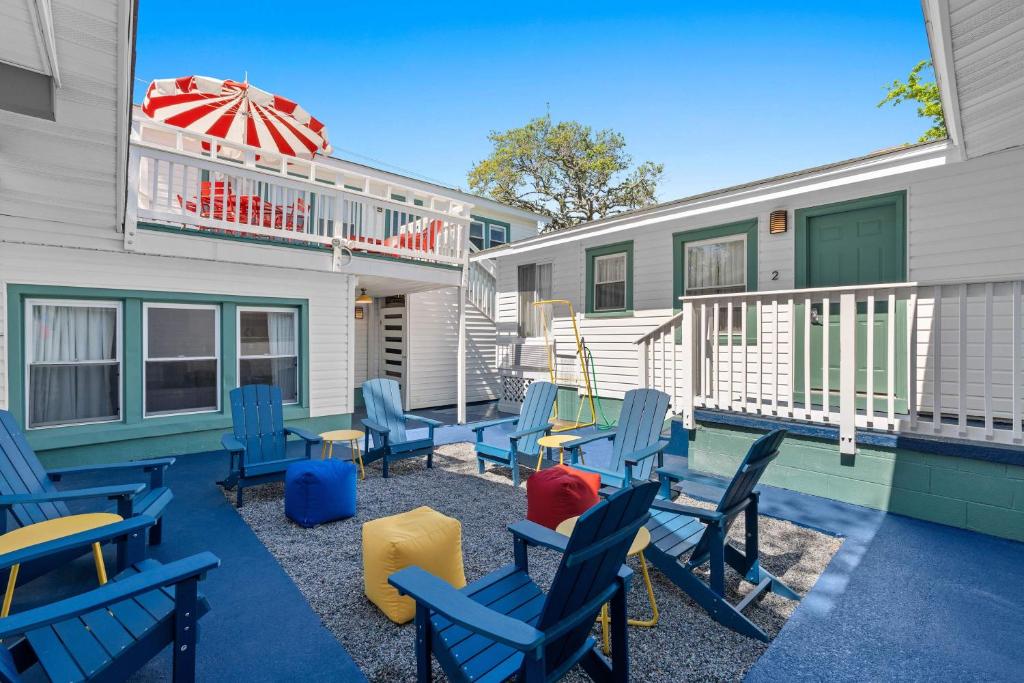 默特尔比奇4BR2BA Sleeps 12 Pet-Friendly Steps to Beach的庭院配有蓝色的椅子和遮阳伞。
