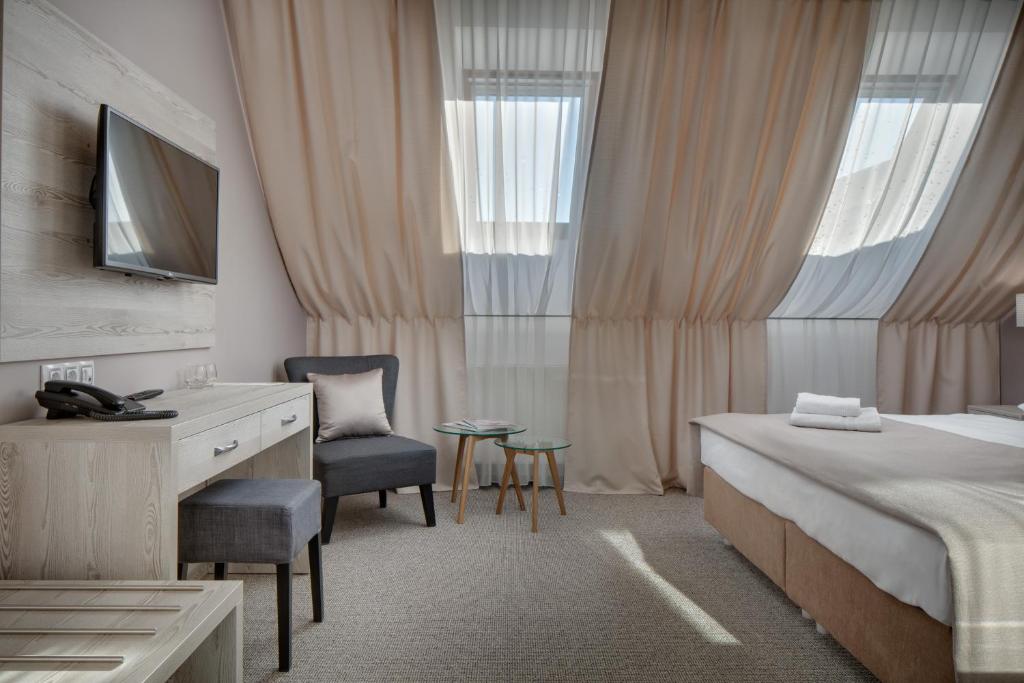 布拉格弗洛伦斯酒店的一间卧室配有一张床、一张桌子和一把椅子