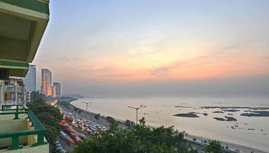 孟买大海绿色酒店 的一条繁忙的街道上,有一群汽车停在海滩上