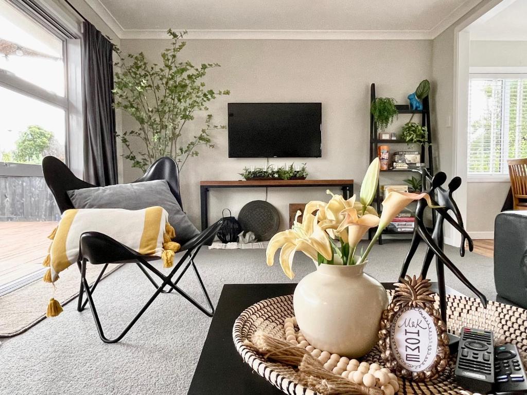 汉密尔顿M&amp;K Home with central air condition, 4 bedrooms, by Chartwell Shopping Centre的客厅的桌子上有一瓶花