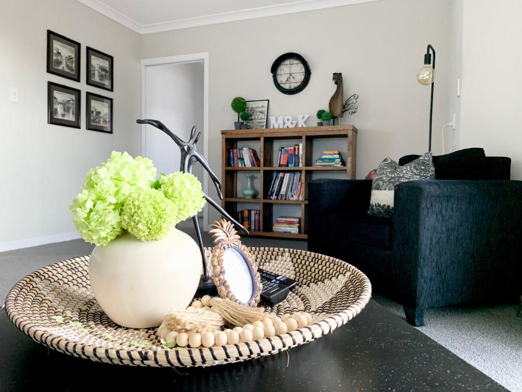 汉密尔顿M&amp;K Home with central air condition, 4 bedrooms, by Chartwell Shopping Centre的客厅配有带花瓶的咖啡桌