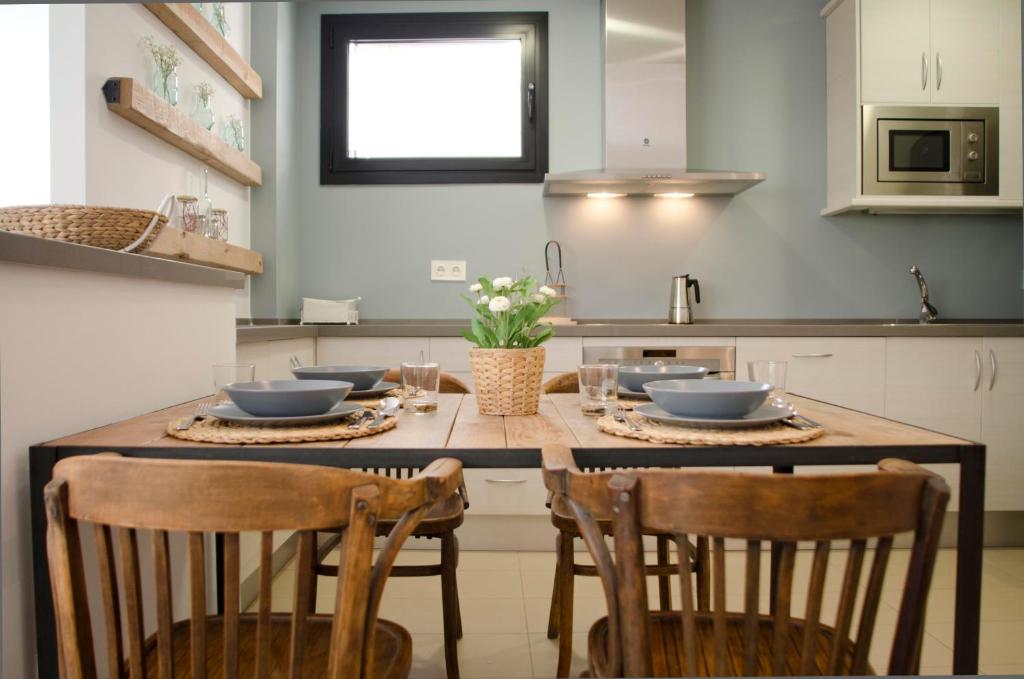 巴塞罗那格拉西亚公寓的厨房配有带椅子的木桌和桌子。