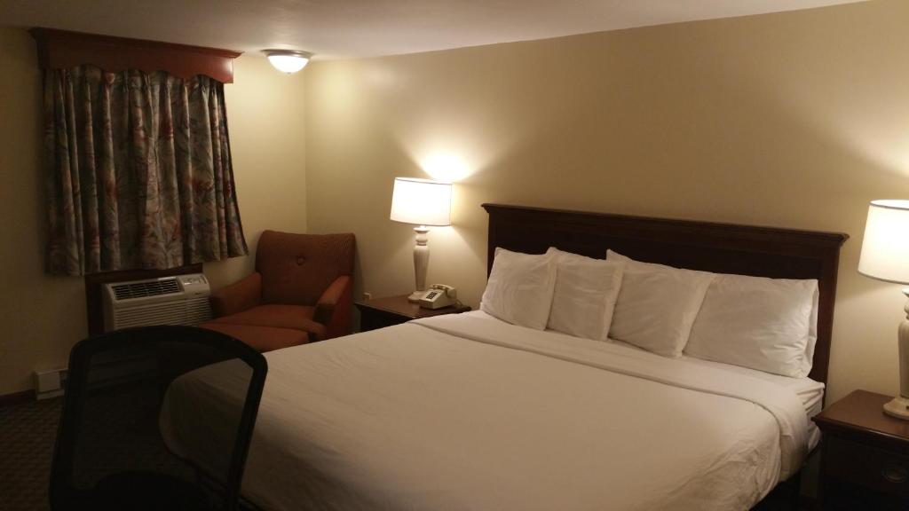 北达特茅斯达特茅斯汽车旅馆的配有一张床和一把椅子的酒店客房