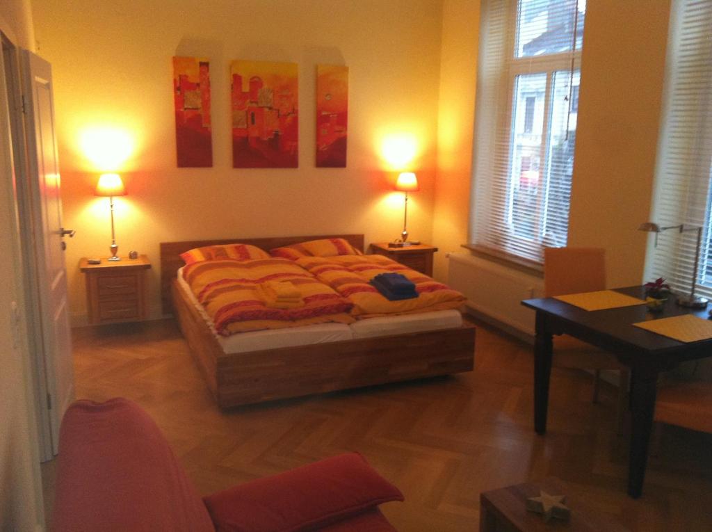不莱梅Business Gästehaus Sonne, Mond & Sterne的一间卧室配有一张带两盏灯和一张桌子的床。