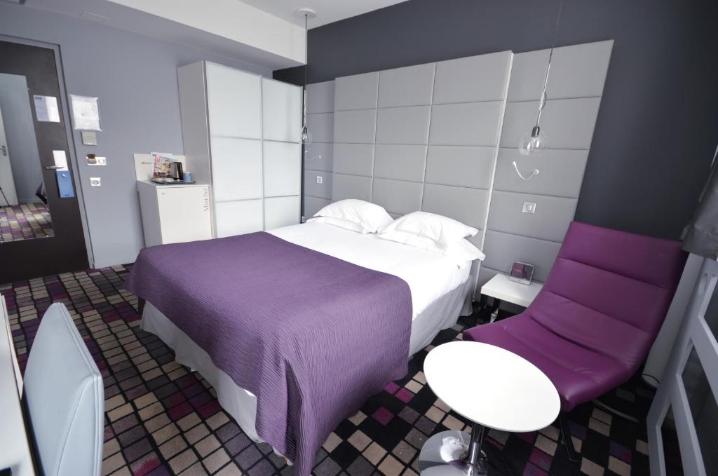 第戎第戎中心克瑞德酒店的配有一张床和一把椅子的酒店客房