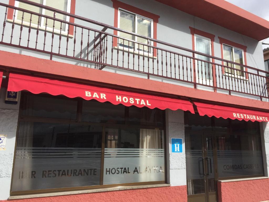 下卡尔瓦拉萨Hostal Alayka的一间酒吧医院,在一座建筑物上装有红色遮阳篷