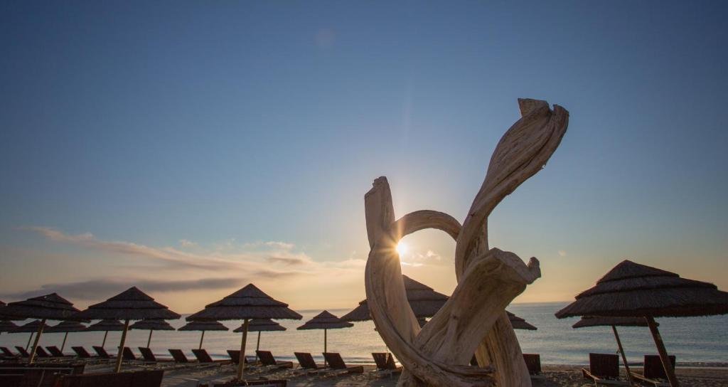 波吉奥· 梅扎纳维拉奇度假酒店的海滩上的一颗心雕塑,上面有遮阳伞