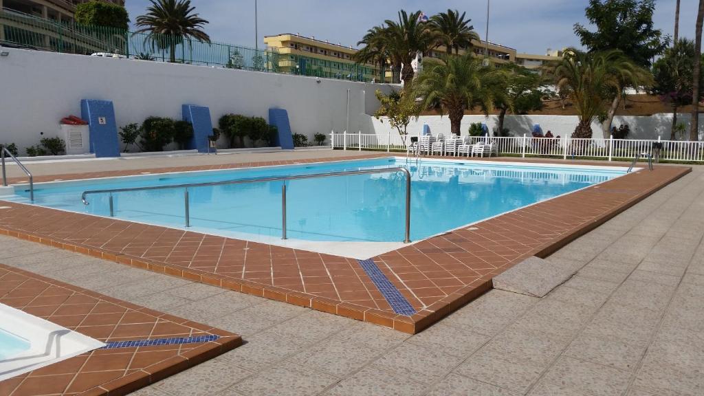 英格兰海滩美景公寓的一座带砖砌走道的游泳池,毗邻一座建筑