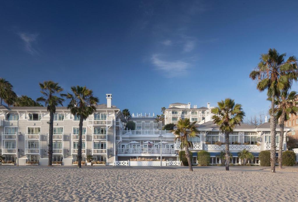 洛杉矶百叶窗海滩酒店的一座白色的大建筑,前面有棕榈树