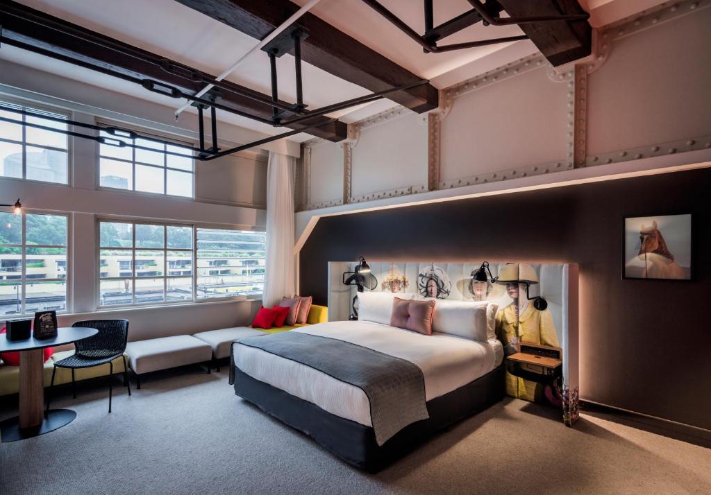 悉尼Ovolo 奥华酒店 - 乌鲁姆鲁的酒店客房设有一张大床和一张沙发。