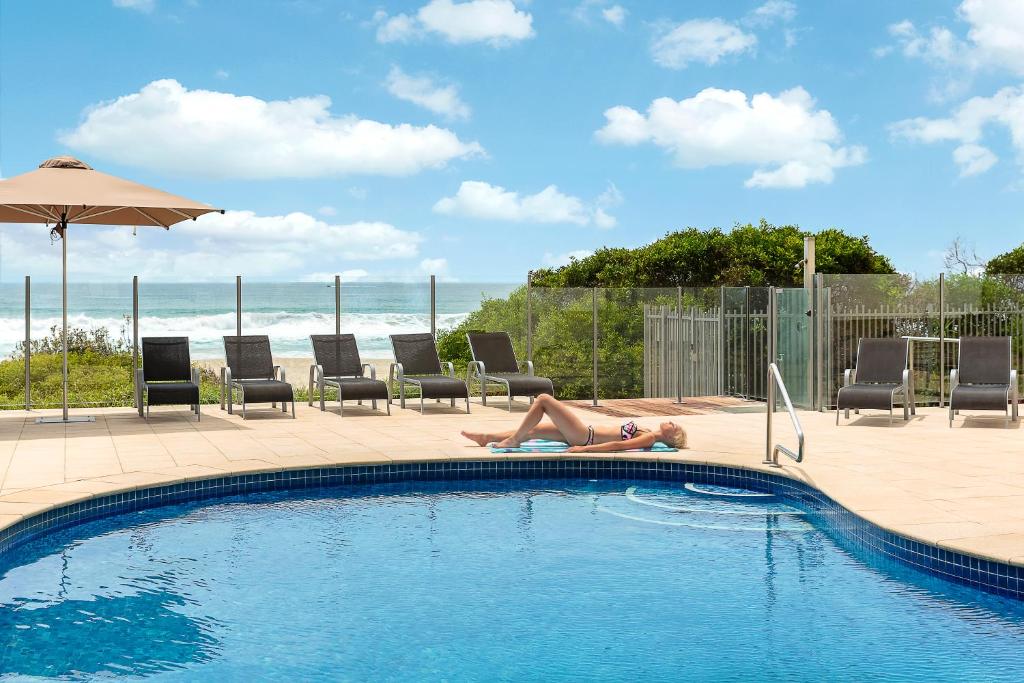 黄金海岸多徹斯特海滩上酒店的躺在游泳池边的女人