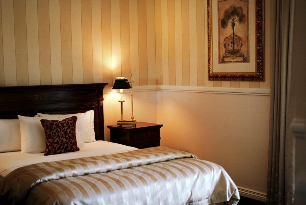 伊萨山红地球精品酒店的一间卧室配有一张床和一张桌子上的台灯