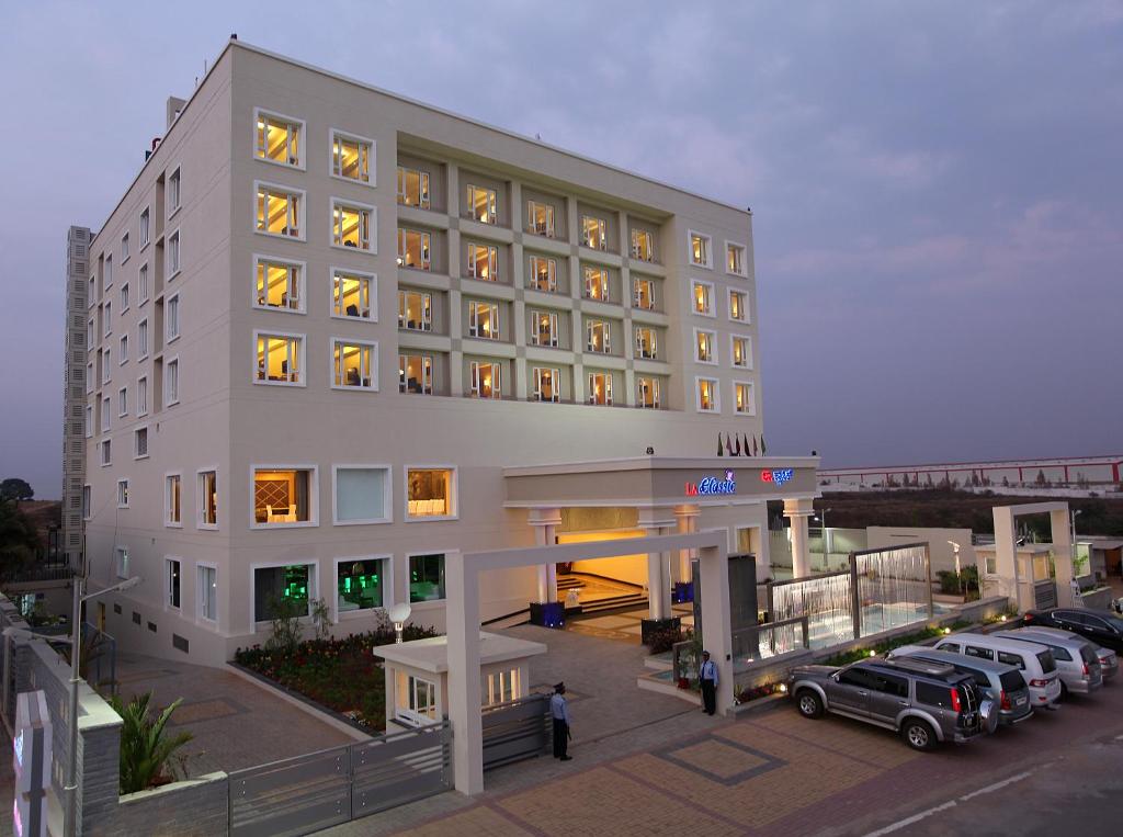 AttibeleLa Classic- Attibele, Hosur的大型白色酒店前面设有停车场