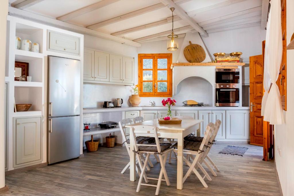 林都斯Lindos Seaside Villa的厨房配有白色橱柜和桌椅