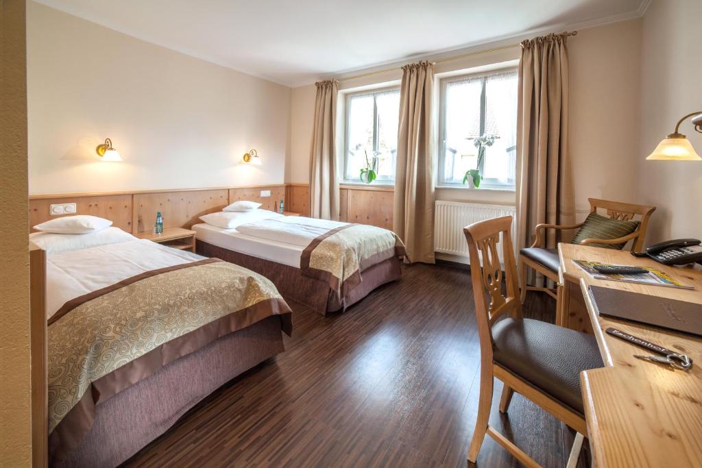 基希海姆艾夏霍夫酒店的酒店客房配有两张床和一张书桌
