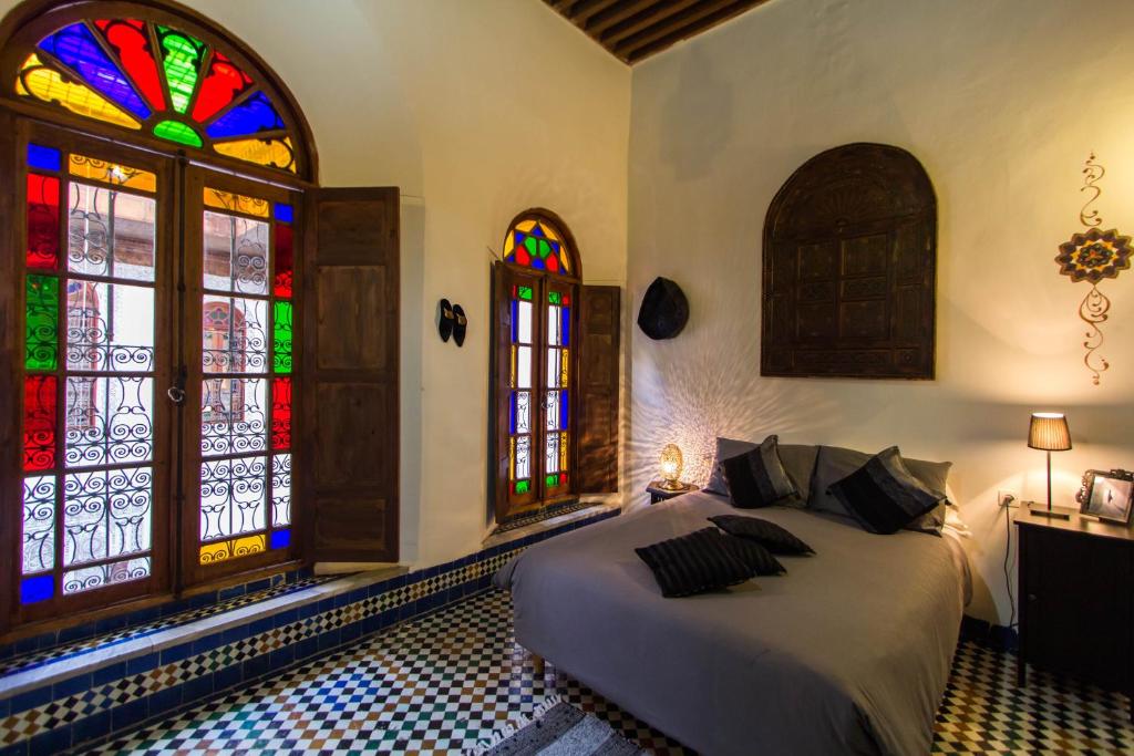非斯达奈玛住宿加早餐旅馆的一间卧室设有床铺和彩色玻璃窗