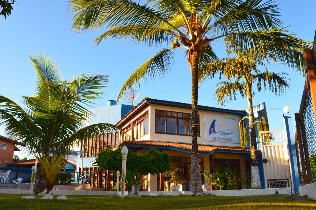 塞古罗港Hotel Porto das Ancoras的一座棕榈树建筑