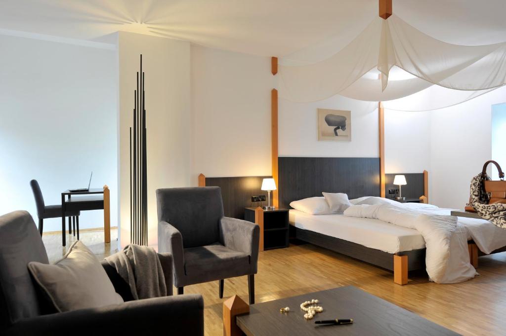 吕德斯海姆吕德斯海姆布鲁尔城堡酒店的一间卧室配有一张床、一张沙发和一把椅子