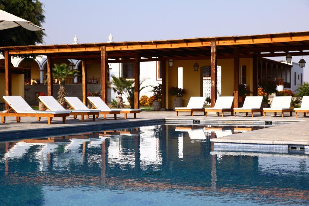 上钦查卡萨哈斯恩达桑吉斯酒店的一组白色躺椅,位于游泳池旁