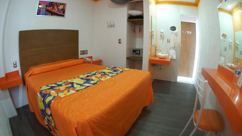 瓦乌奇南戈Hotel Yekkan的一间卧室配有一张带橙色床罩的床