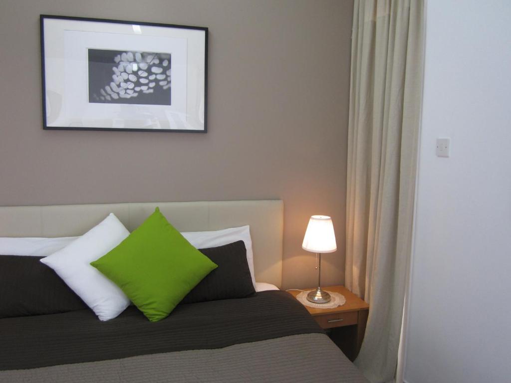 尼科西亚DownTown Living By 'Flats Nicosia'的卧室配有一张带绿色枕头的床